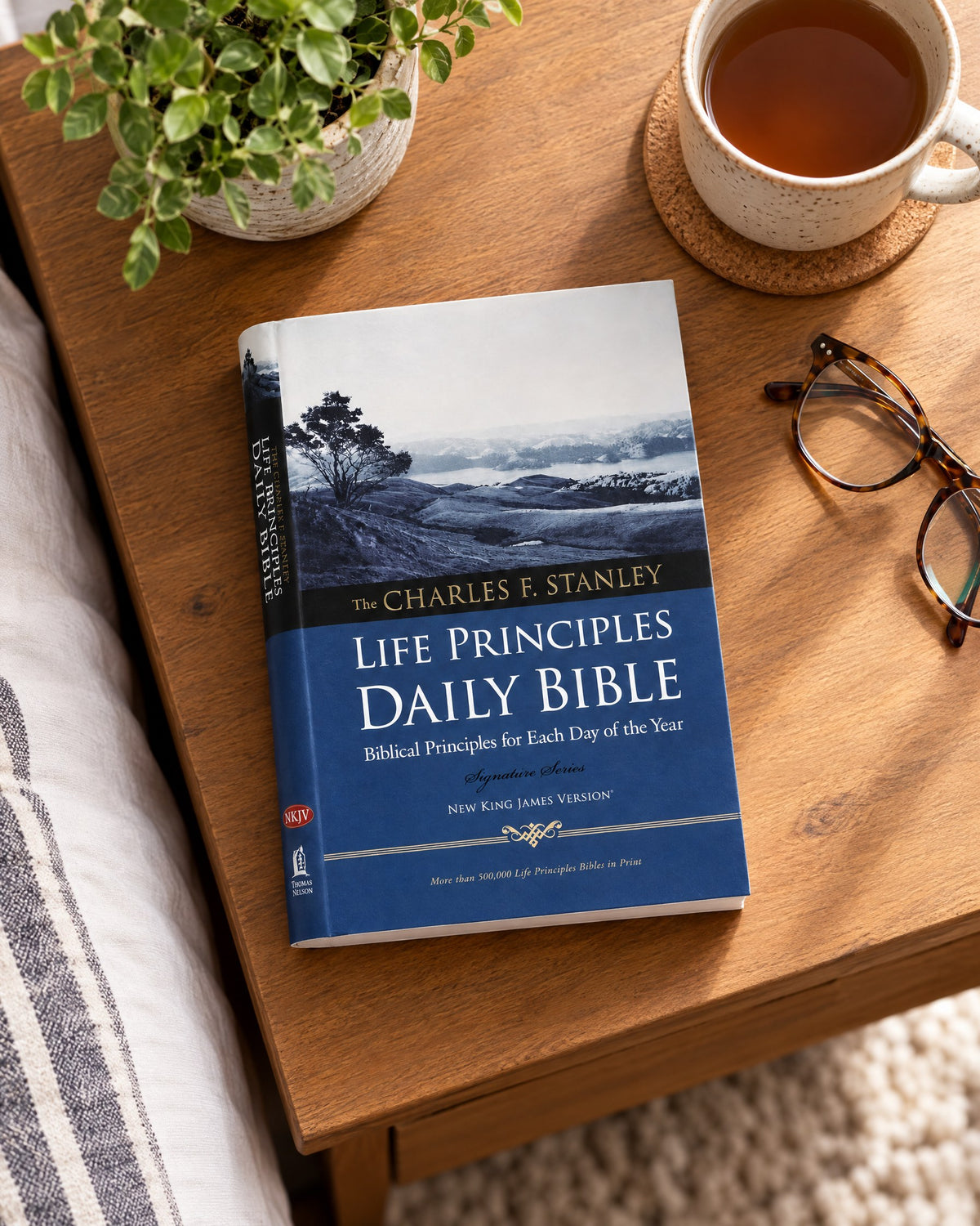 The Life Principles Daily Bible (NKJV) on a bedside table